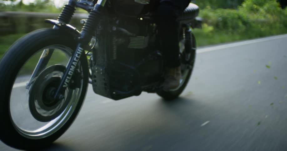 A motorcyclist rides on a rural road