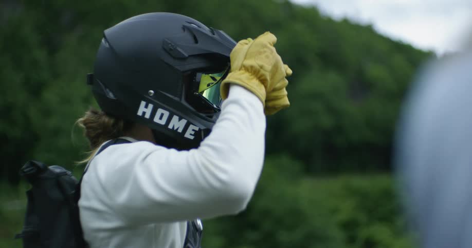 A motorcyclist removes his goggles