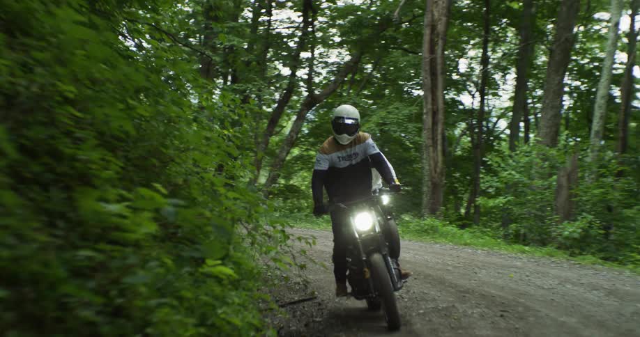 Motorcyclists ride in a forest