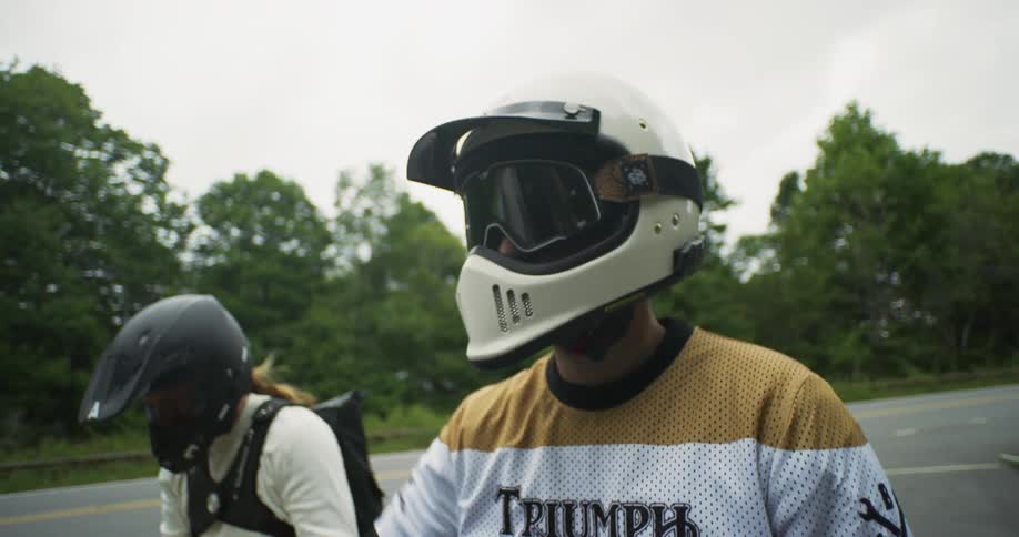 Two motorcyclists sit and talk together