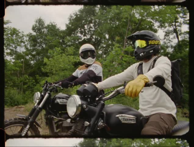 Two men sit on motorcycles