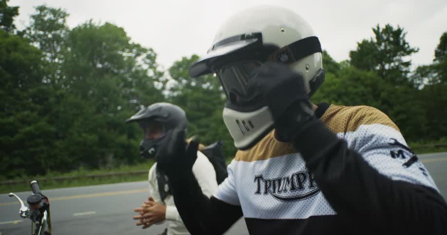 Two motorcyclists sit together