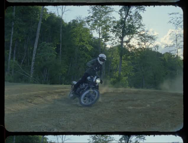 A man skids out on a dirt bike