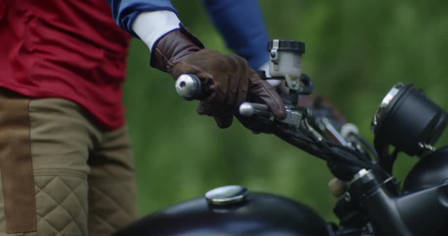 A man stands up on a motorcycle
