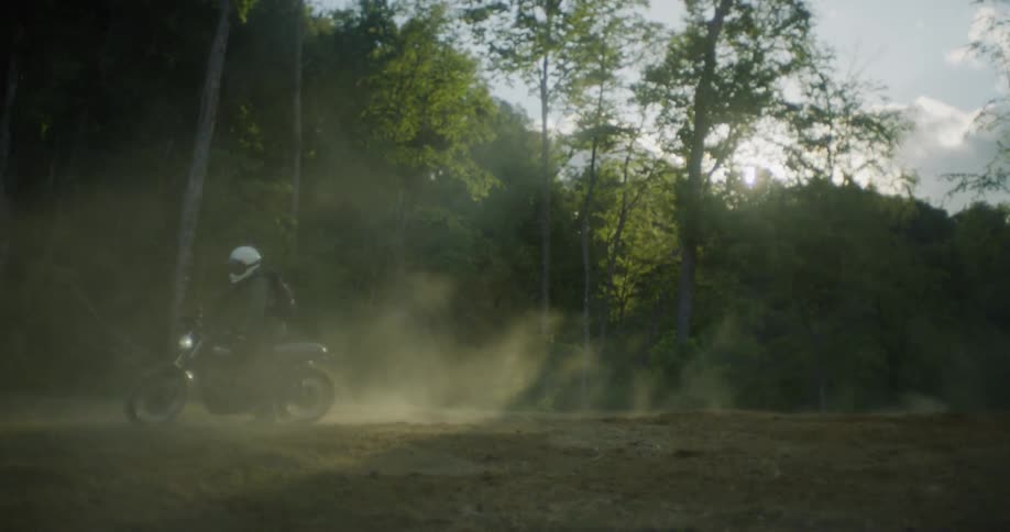 A motorcyclist kicks up dust while spinning in dirt