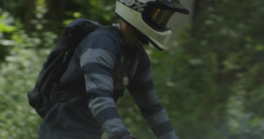 A man stands up while riding a motorcycle