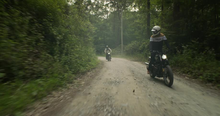 Motorcyclists ride in a forest