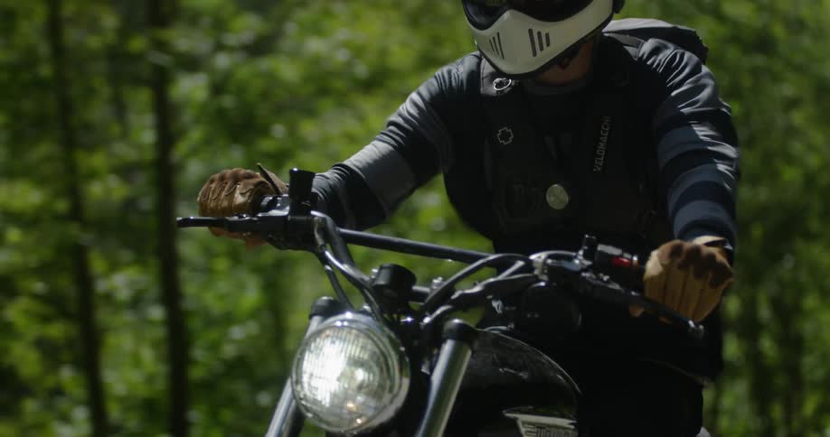 A motorcyclist rides in a forest