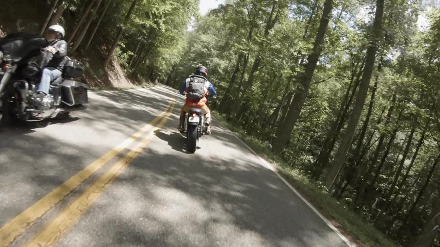 A motorcyclist rides in a forest