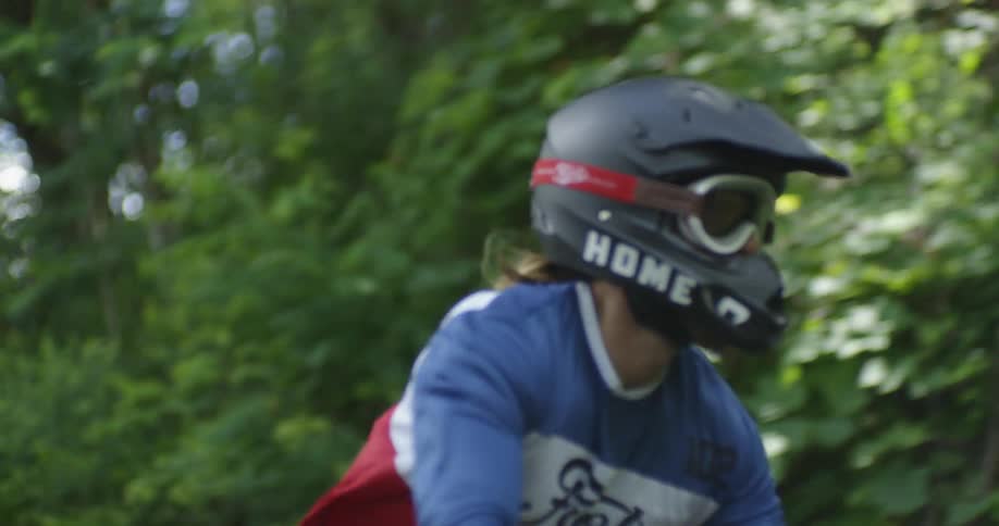 A man stands up on a moving motorcycle