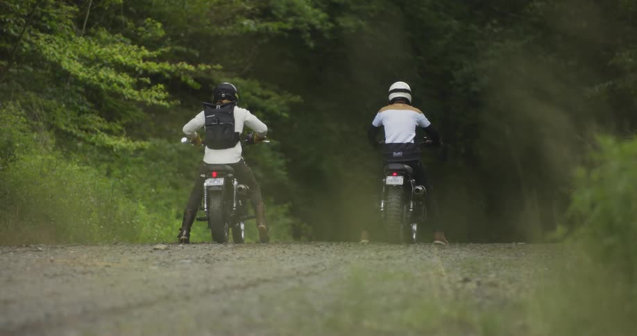 Motorcyclists ride in a forest