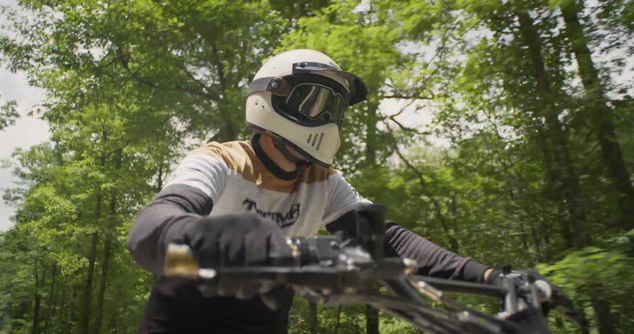 A motorcyclist rides in a forest