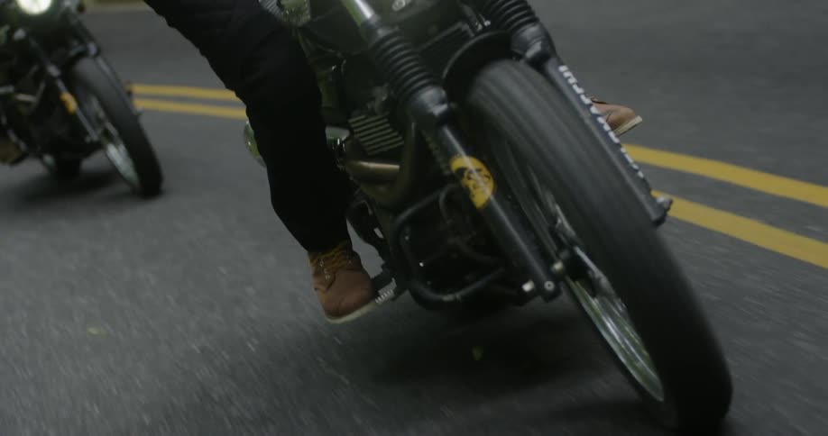 Motorcycles travel near the yellow lines on a highway