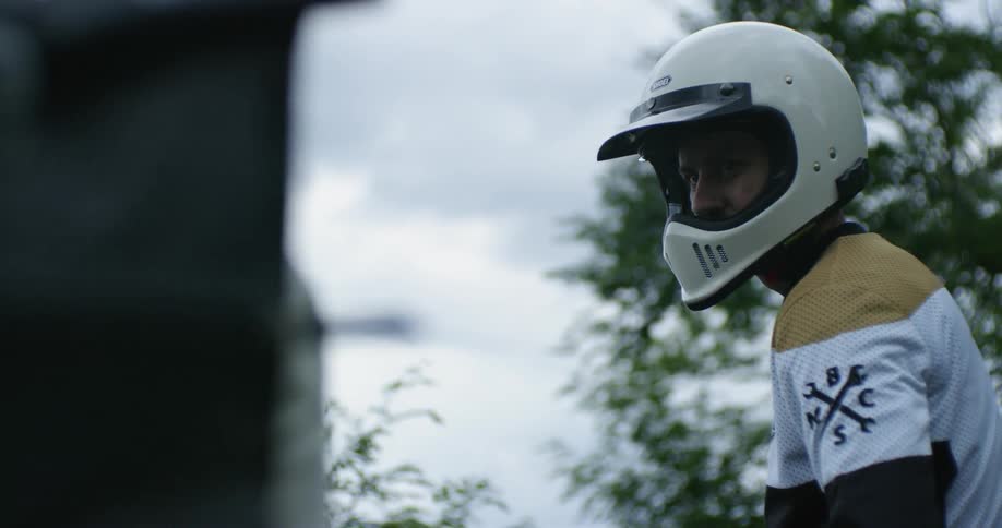 A man stands outside with a motorcycle helmet on