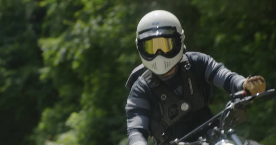 Two motorcyclists drive in a zigzag pattern