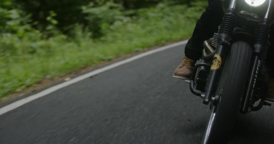 A motorcyclist rides down a road