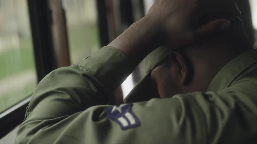 A soldier puts on his hat