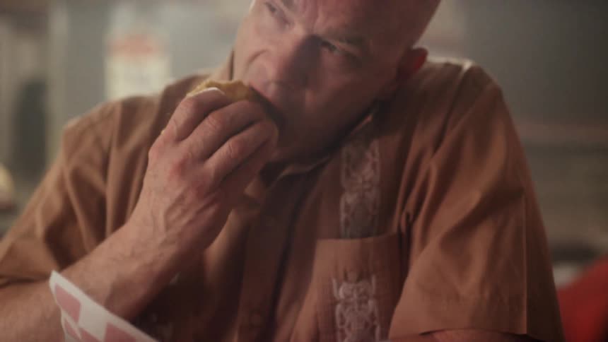 A man eats a burger at a restaurant