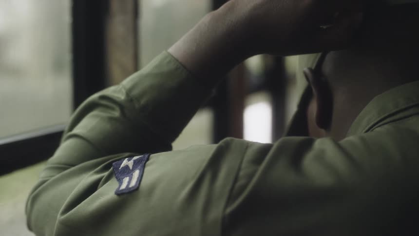 A soldier puts on his hat
