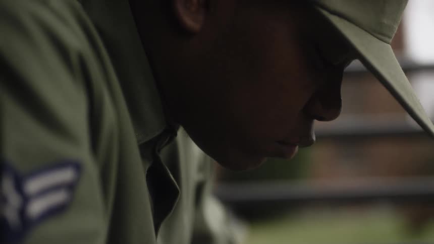 A service member sits outside