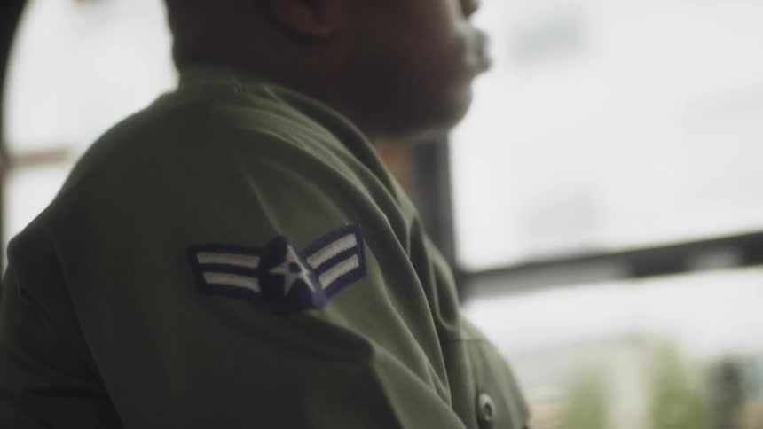 A service member rides a bus