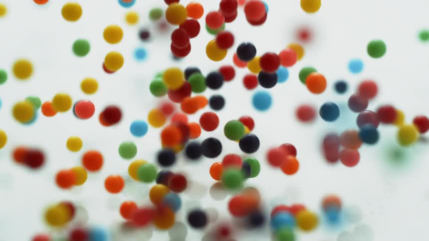 Colorful balls fall and bounce on a white surface