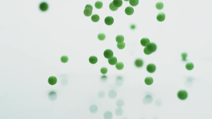 Green balls bounce on a white surface
