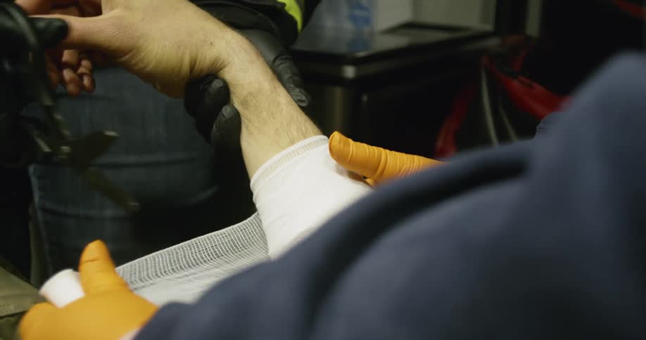 Medics bandage a person's arm