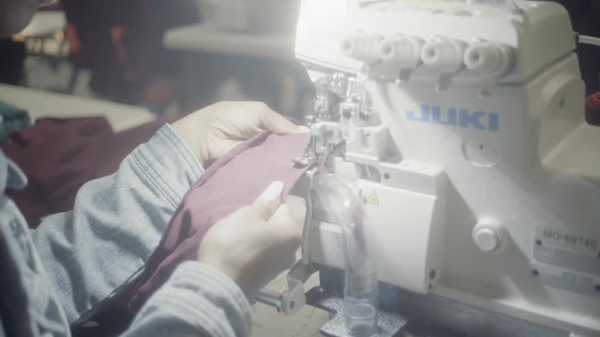 A woman stitches with a sewing machine