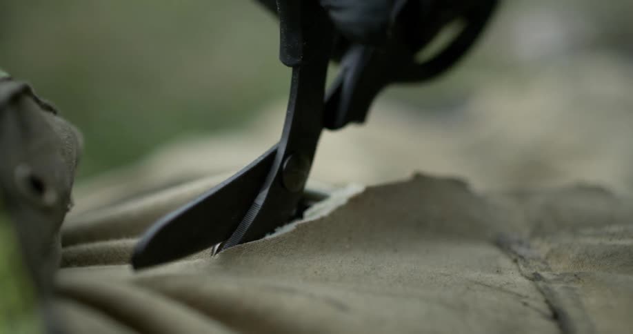 Scissors are cutting through a uniform