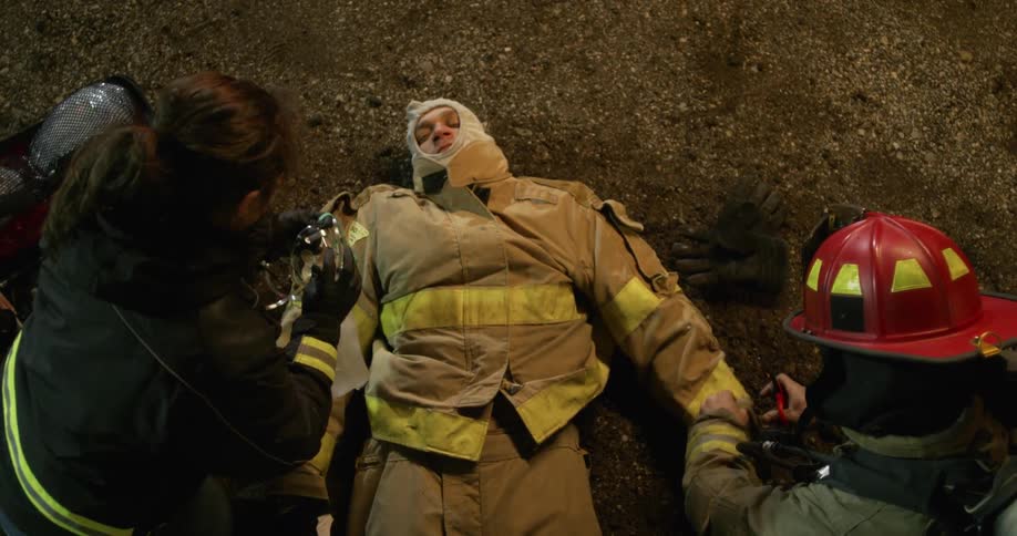 Emergency responders help an injured firefighter