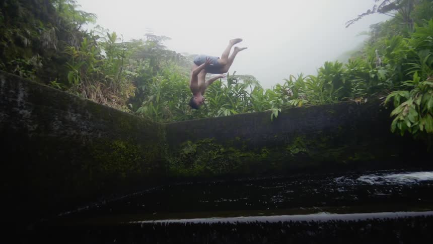 A man does a backflip into a lake