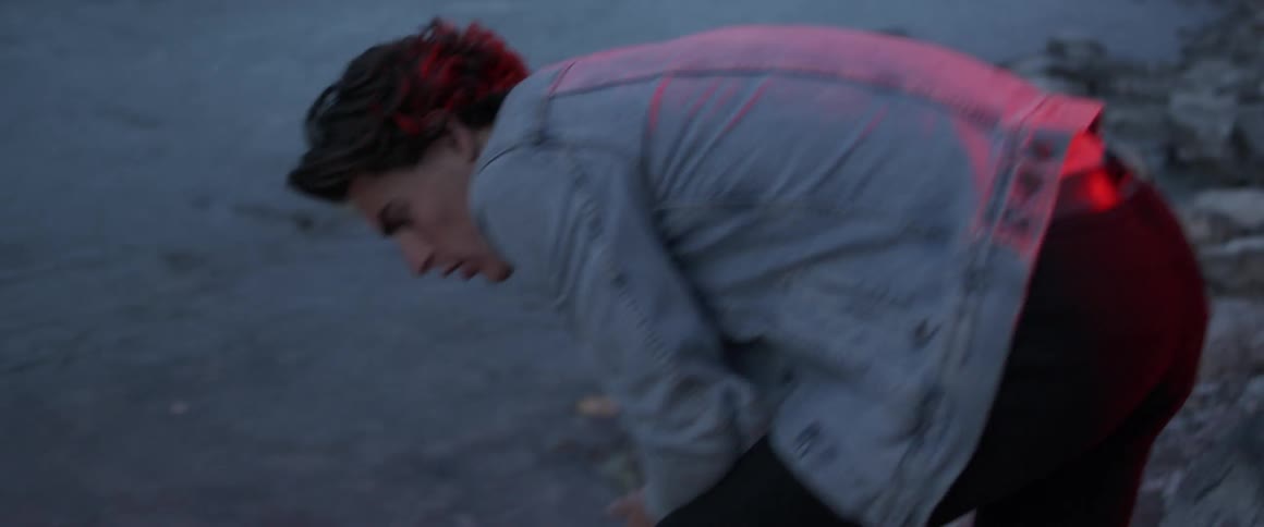 The man leans down looking in the water