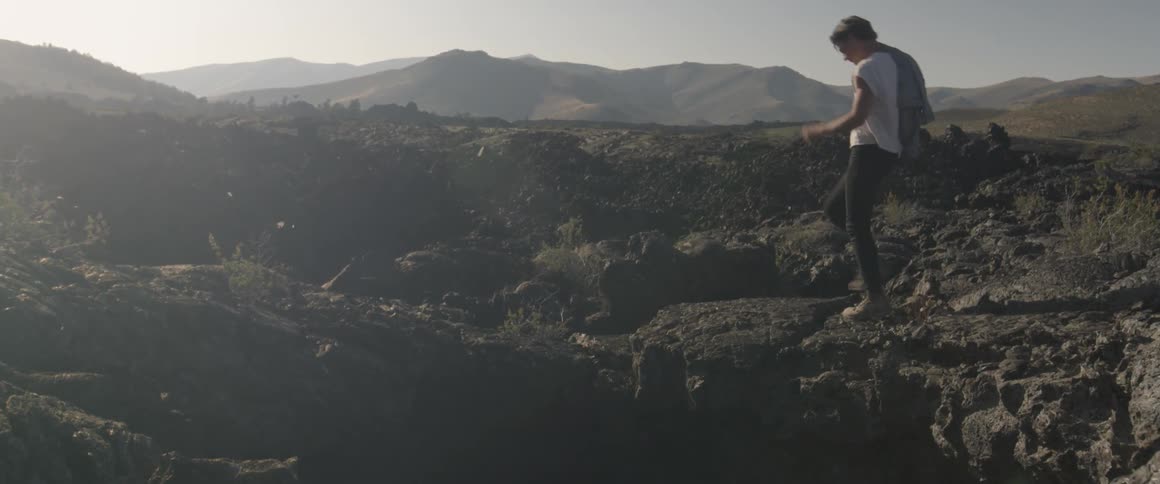A man hikes over some rocks