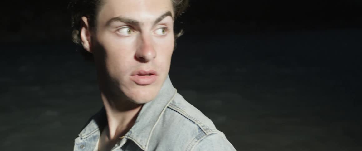 Man looks behind him as he stands in the dark