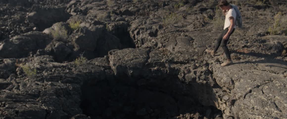 Man walks over rocky landscape