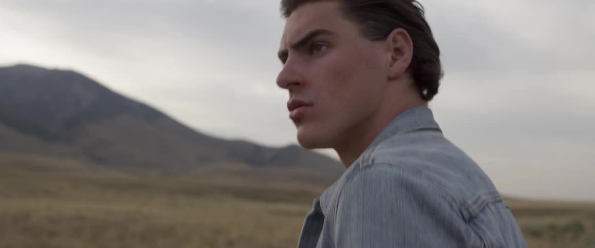 Man walks in a field as he looks around