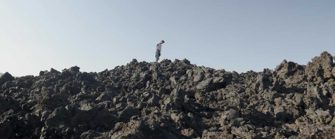 A man climbs over the tall rocks