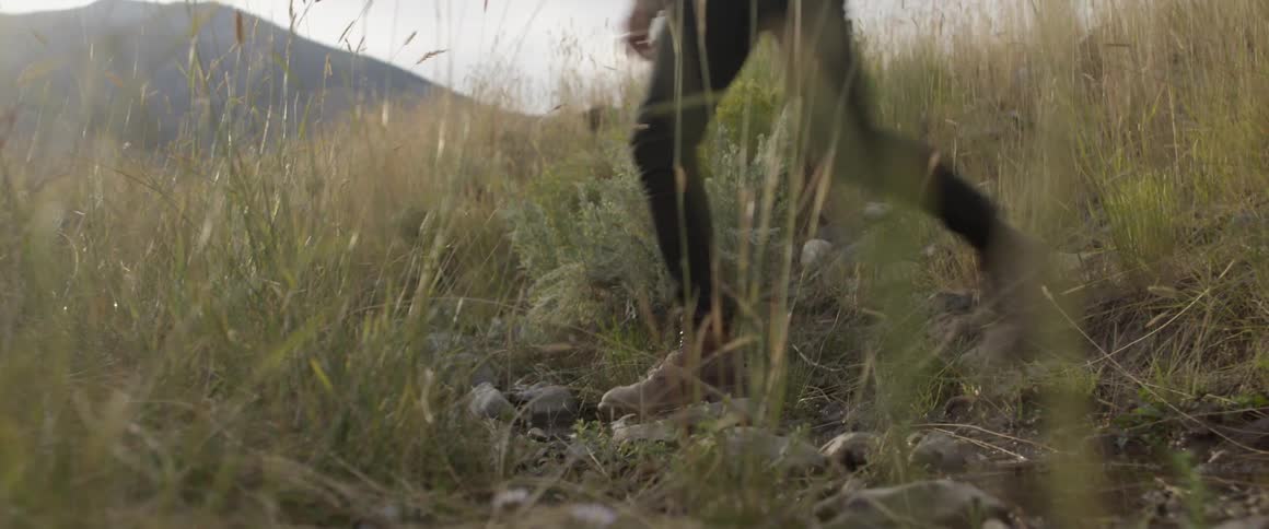 A woman walks through the grass