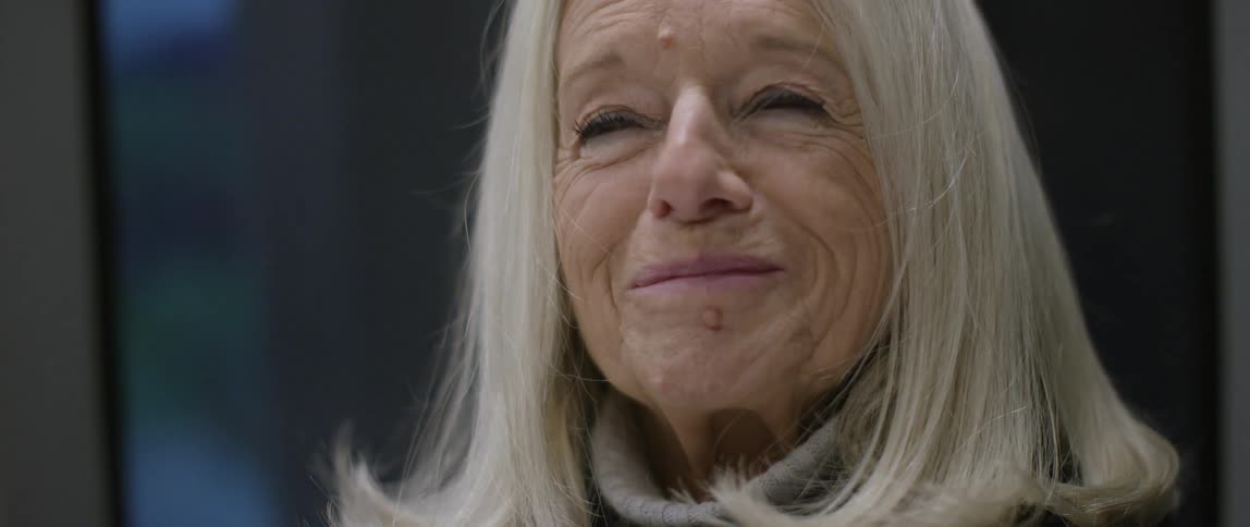 A old woman is lost in thoughts and is silently smiling