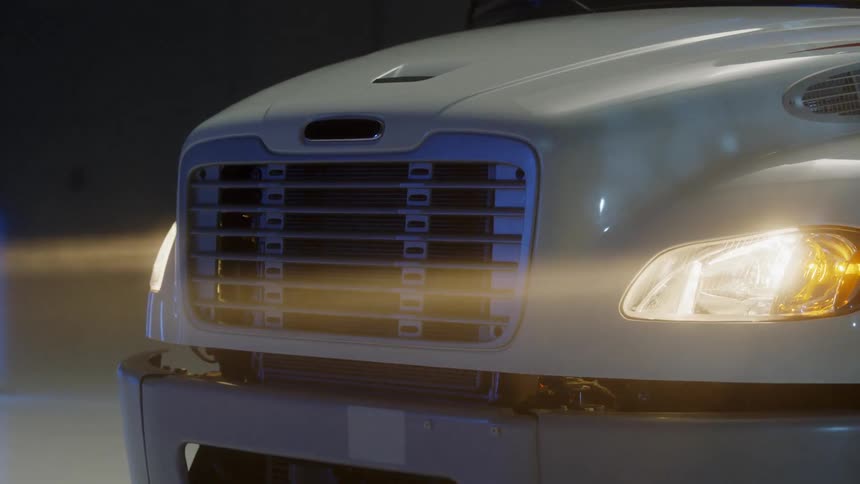 The headlights and grill of a parked truck at night