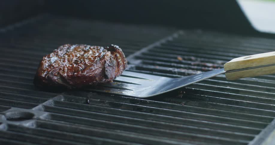 A steak is cooked on a grill