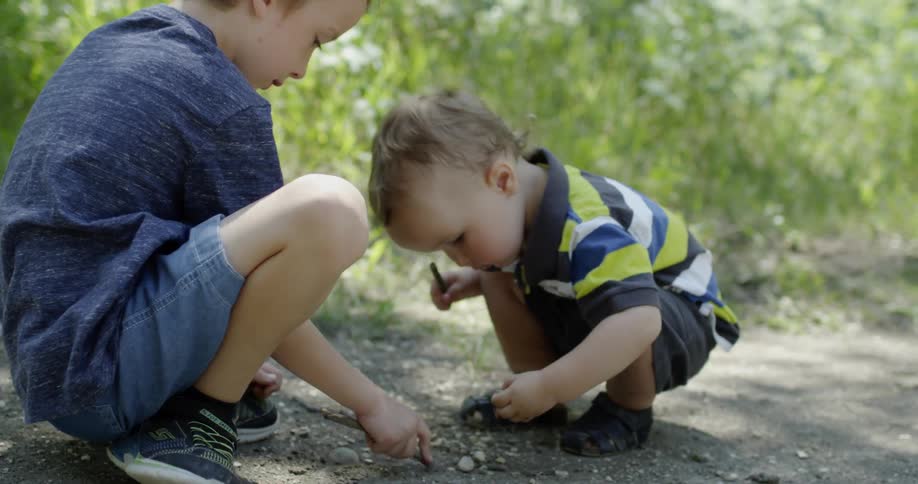 Two young boys play in nature