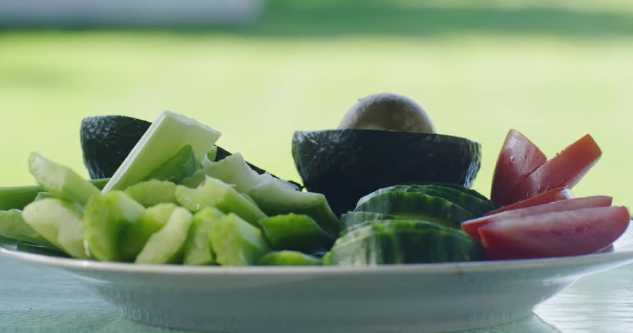 A plate full of celery avocado and cucumbers