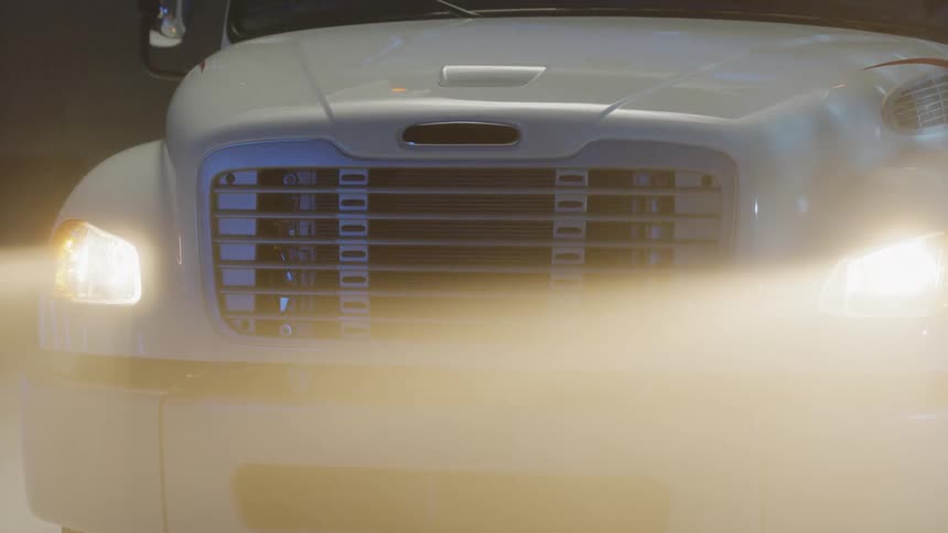 Headlights shine on a semi-truck