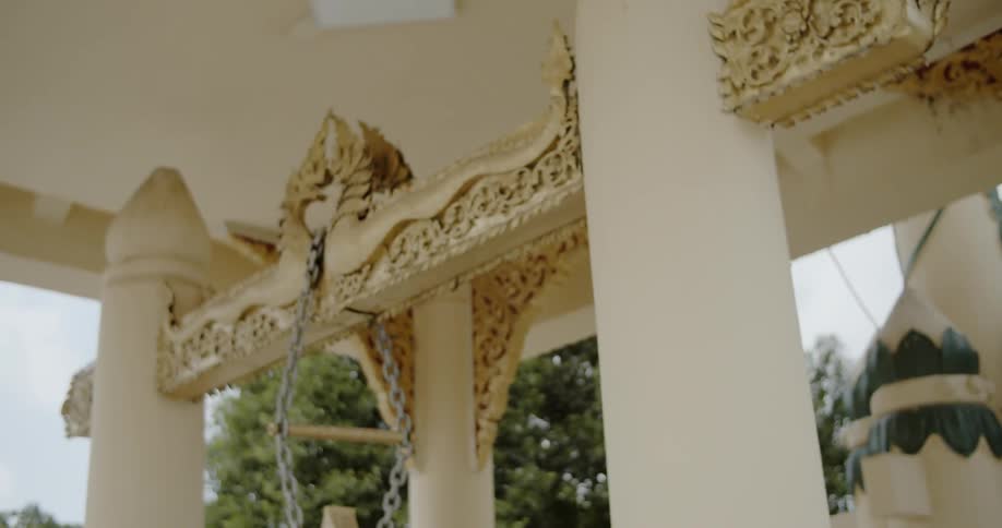 An item hangs from a chain looped between two dragon decorated columns