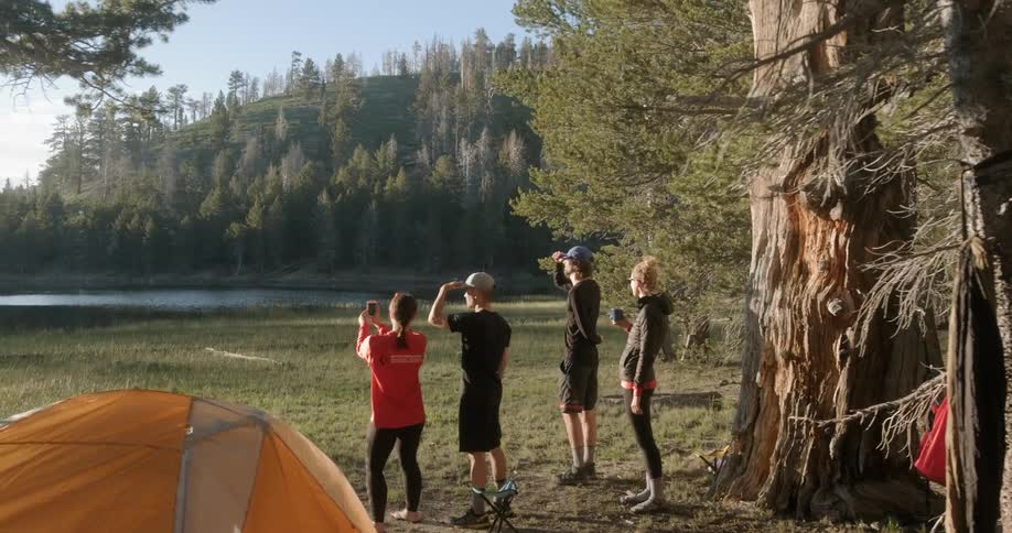 People are standing in campground and observing lake view