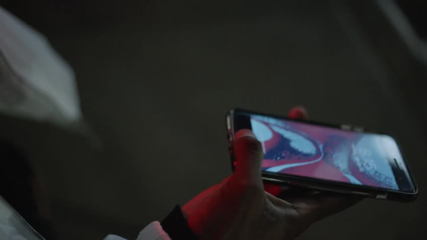 Person holds their phone scrolling on it
