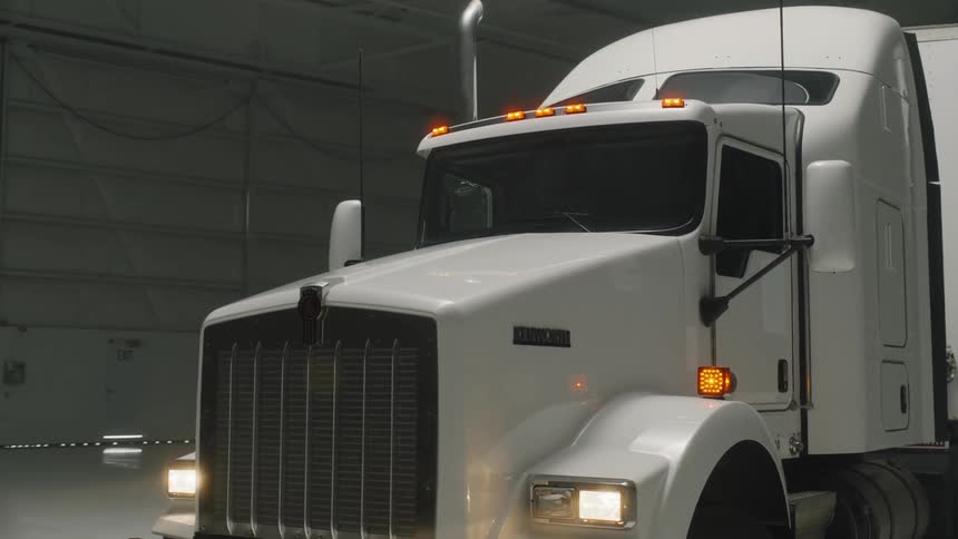 A  big rig truck sits parked in a garage