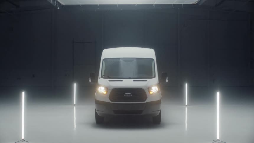 A van sits in a garage surrounded by lights